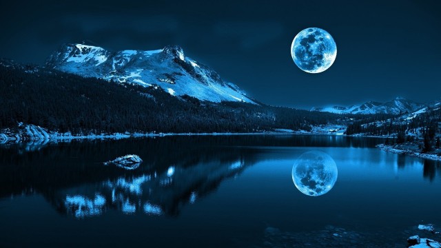 Reflection of snowy mountain on body of water under full moon wallpaper